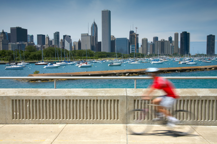 Man on a bicycle whizzes by with the Chicago skyline in background